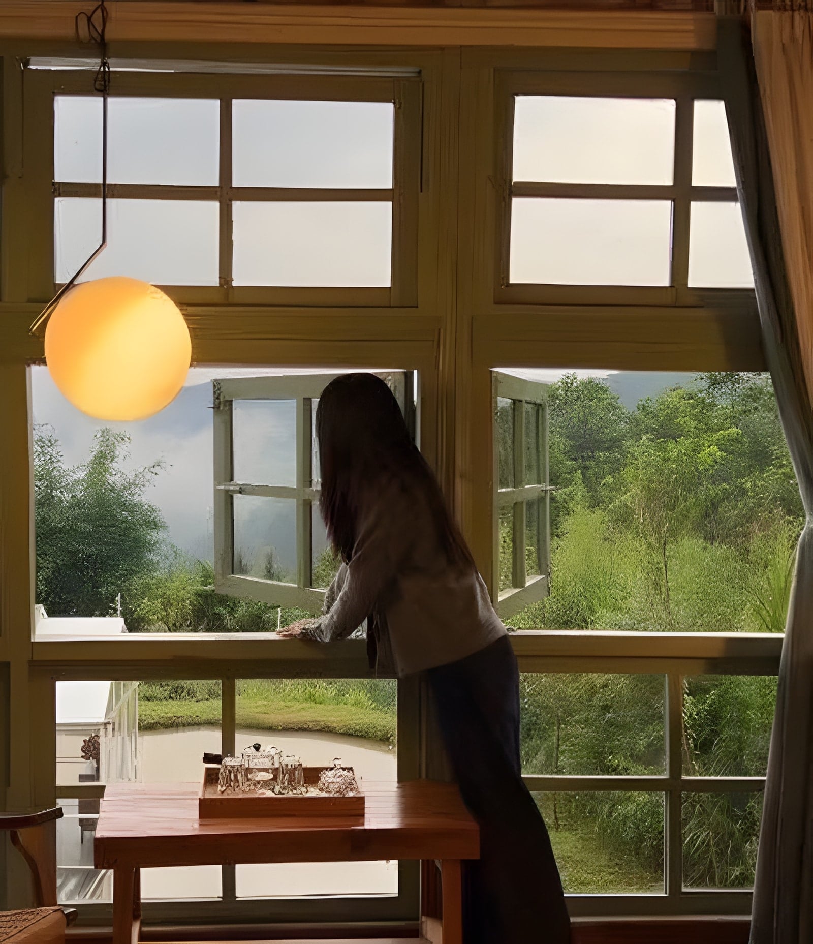 Khung cửa sổ gỗ mở ra đồi xanh, đèn tròn vàng